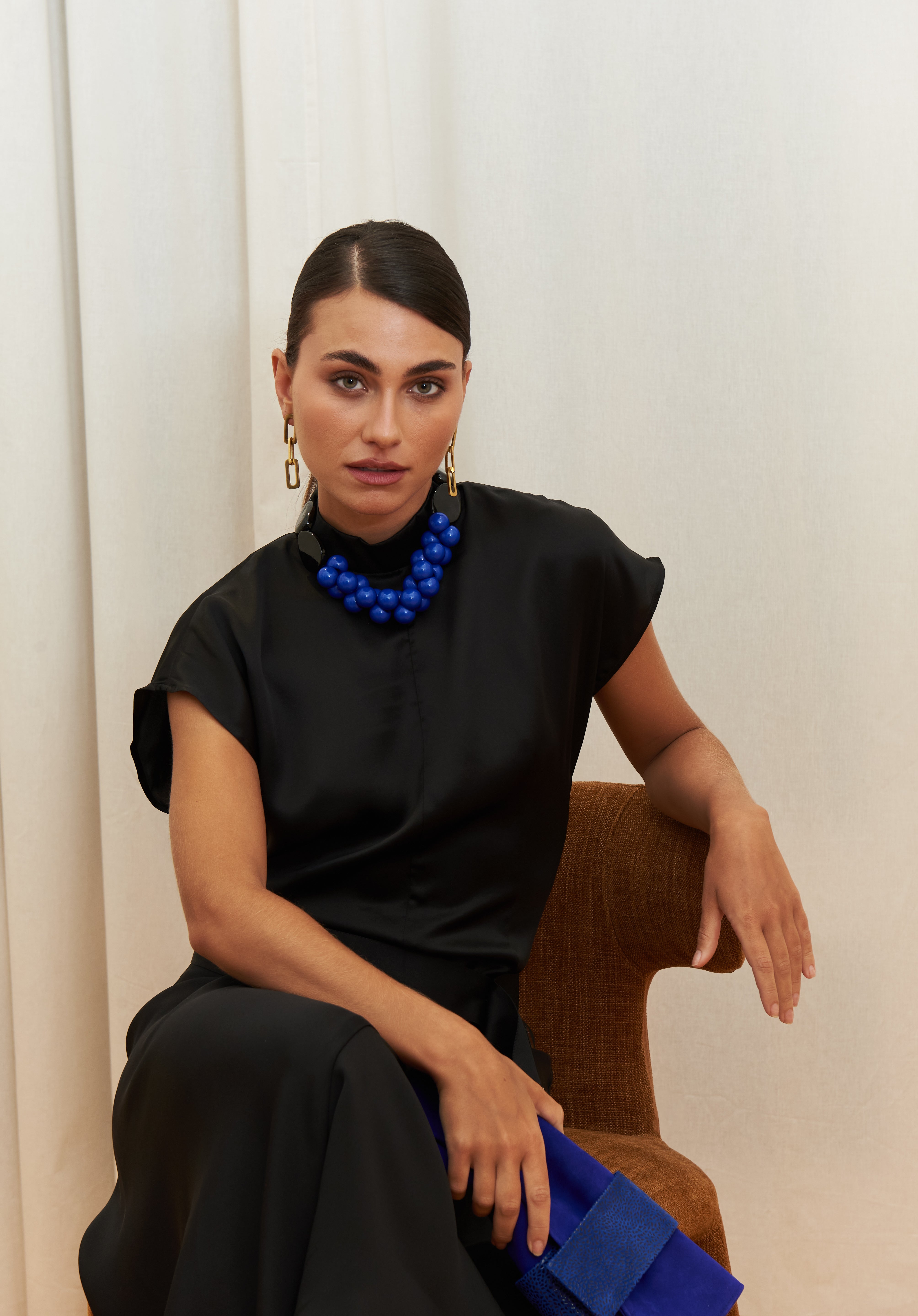Midnight Muse Top, crafted from 100% certified Como silk, features a sleek silhouette with a refined V-neckline at the back. Its elegant drape and timeless design offer a sophisticated touch, effortlessly transitioning from daytime refinement to evening allure.