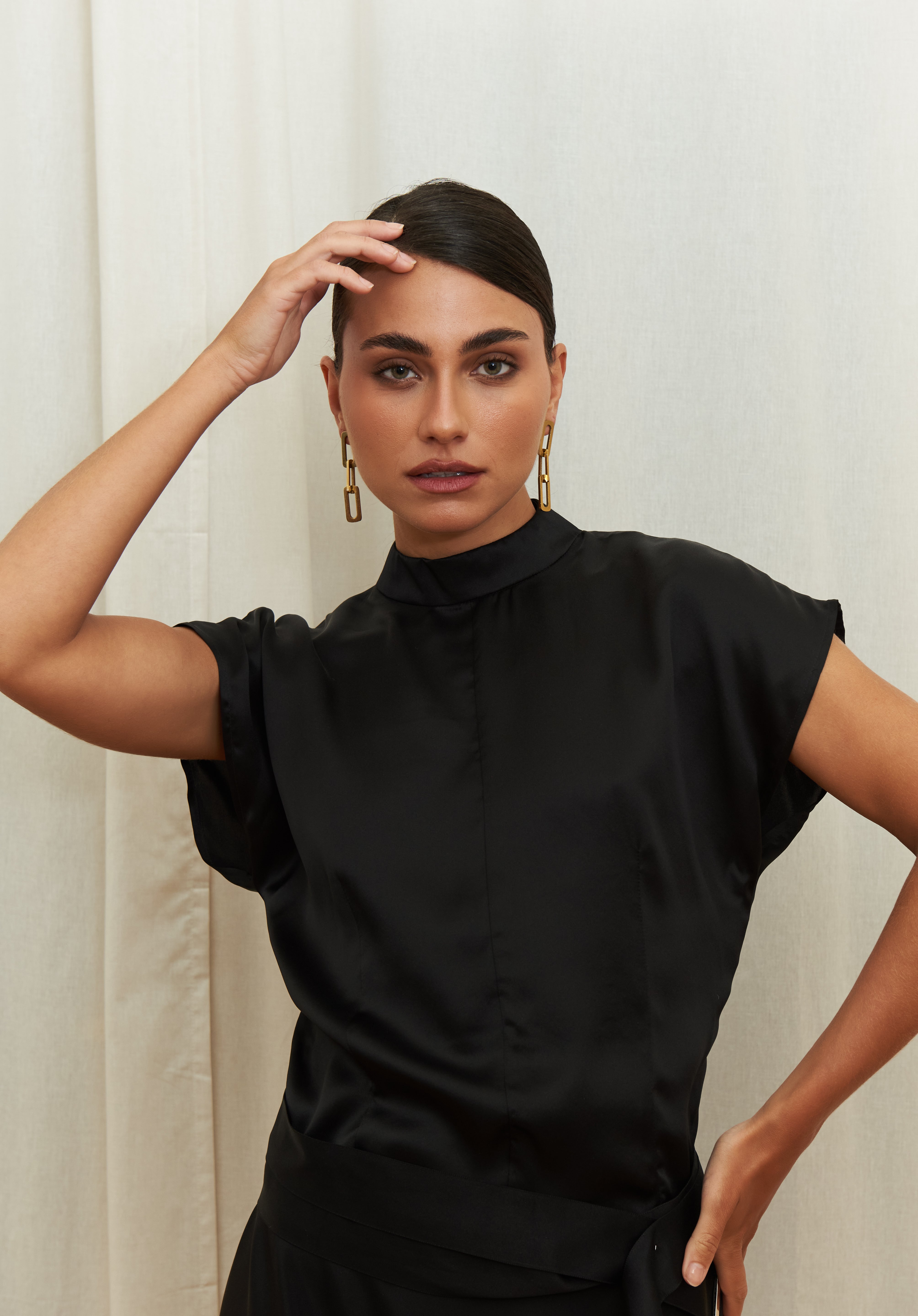 Midnight Muse Top, crafted from 100% certified Como silk, features a sleek silhouette with a refined V-neckline at the back. Its elegant drape and timeless design offer a sophisticated touch, effortlessly transitioning from daytime refinement to evening allure.