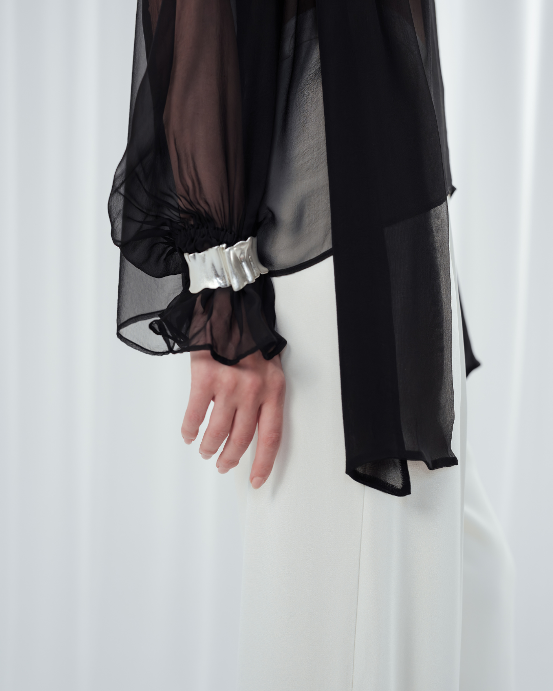 Noir Veil Blouse in 100% certified Como silk voile offers sheer elegance with voluminous sleeves and a delicate necktie—ideal for refined, modern styling.