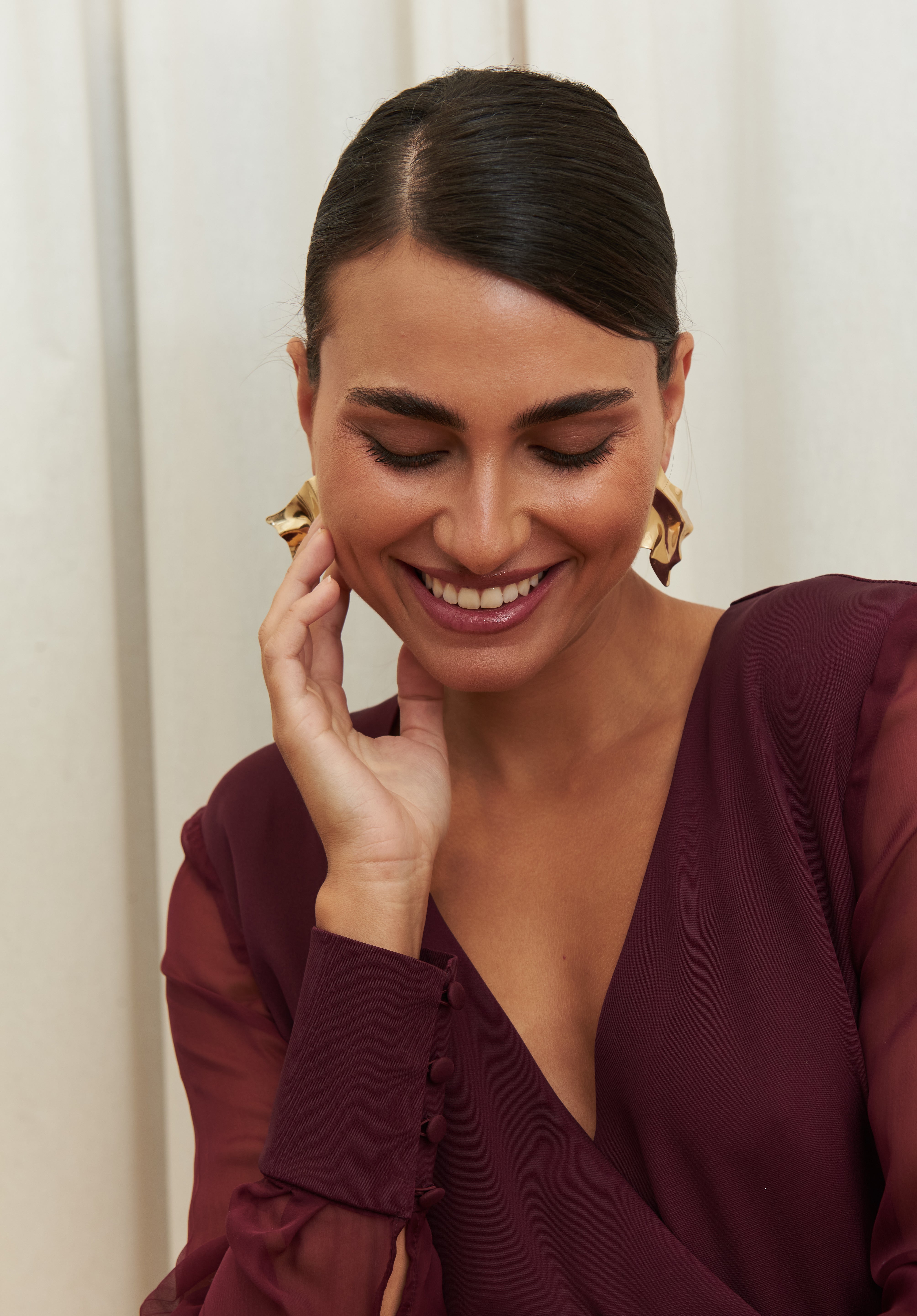 Amethyst Grace Dress in rich burgundy features a golden zamak accessory, sheer sleeves, and silk-covered buttons for opulent sophistication at formal events.