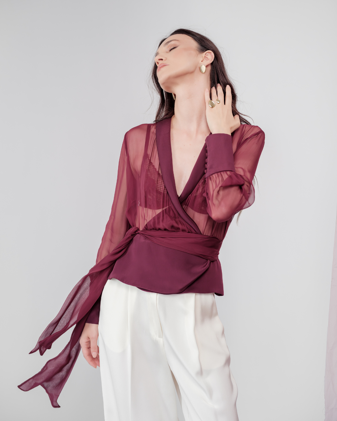 Berry Dusk Blouse in rich burgundy hue features a wrap design with silk-covered buttons and an adjustable waist tie - perfect for sophisticated day-to-evening wear.