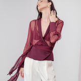 Berry Dusk Blouse in rich burgundy hue features a wrap design with silk-covered buttons and an adjustable waist tie - perfect for sophisticated day-to-evening wear.