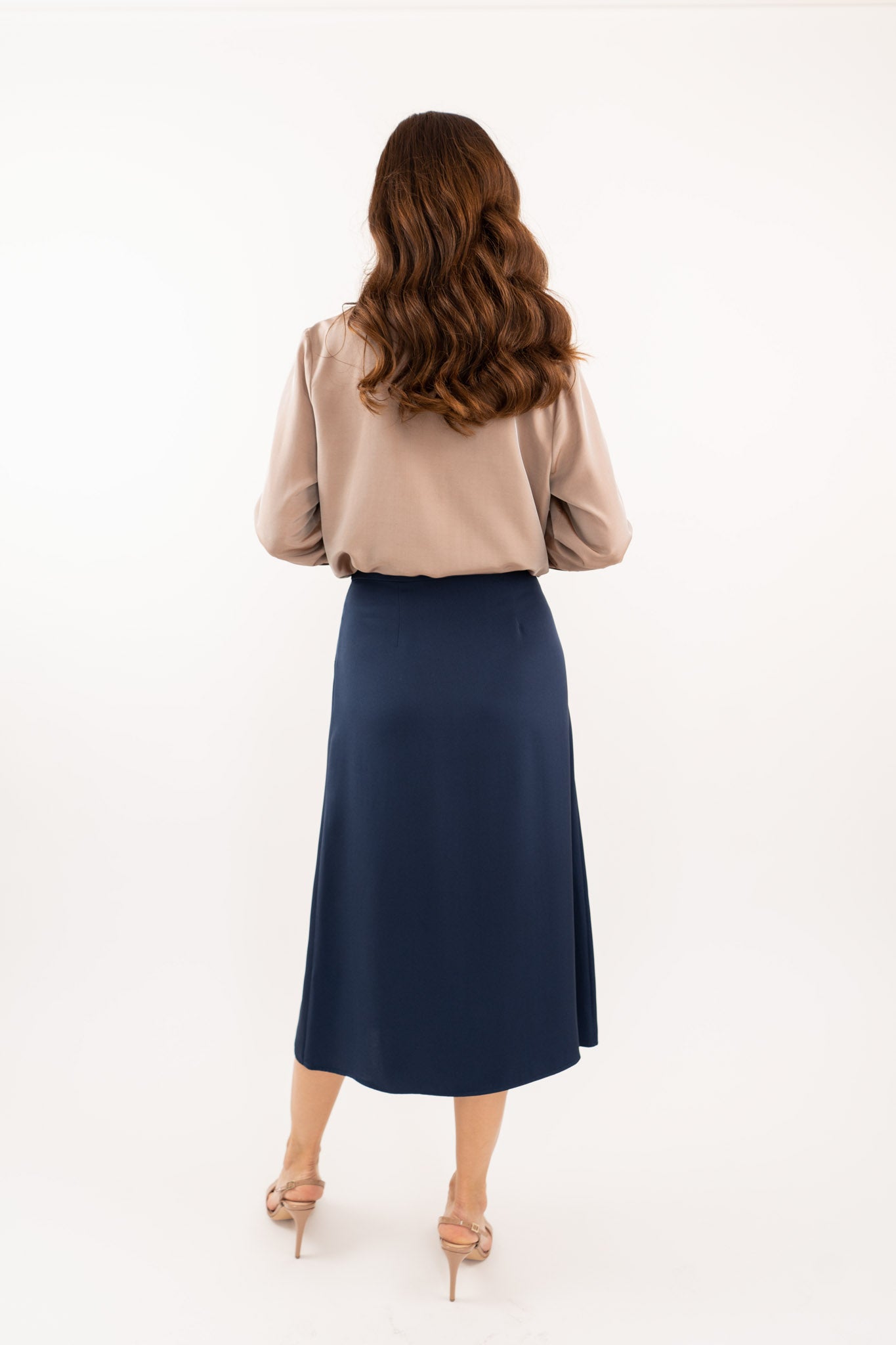 Navy-blue midi silk skirt in 100% silk, smooth and seamless finish, high-waisted fit, back view.