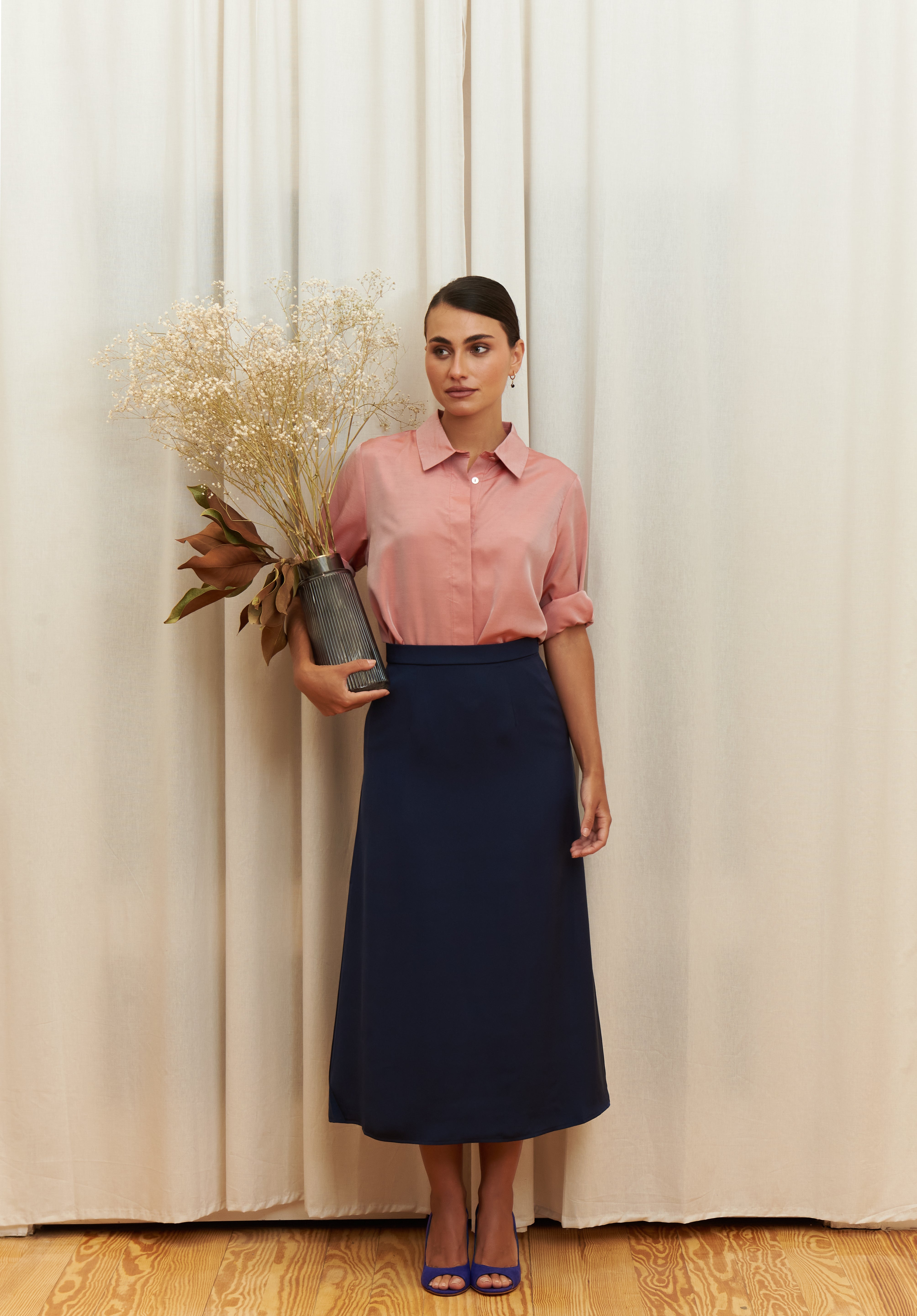 Navy-blue midi silk skirt in 100% silk, smooth and seamless finish, high-waisted fit, back view.