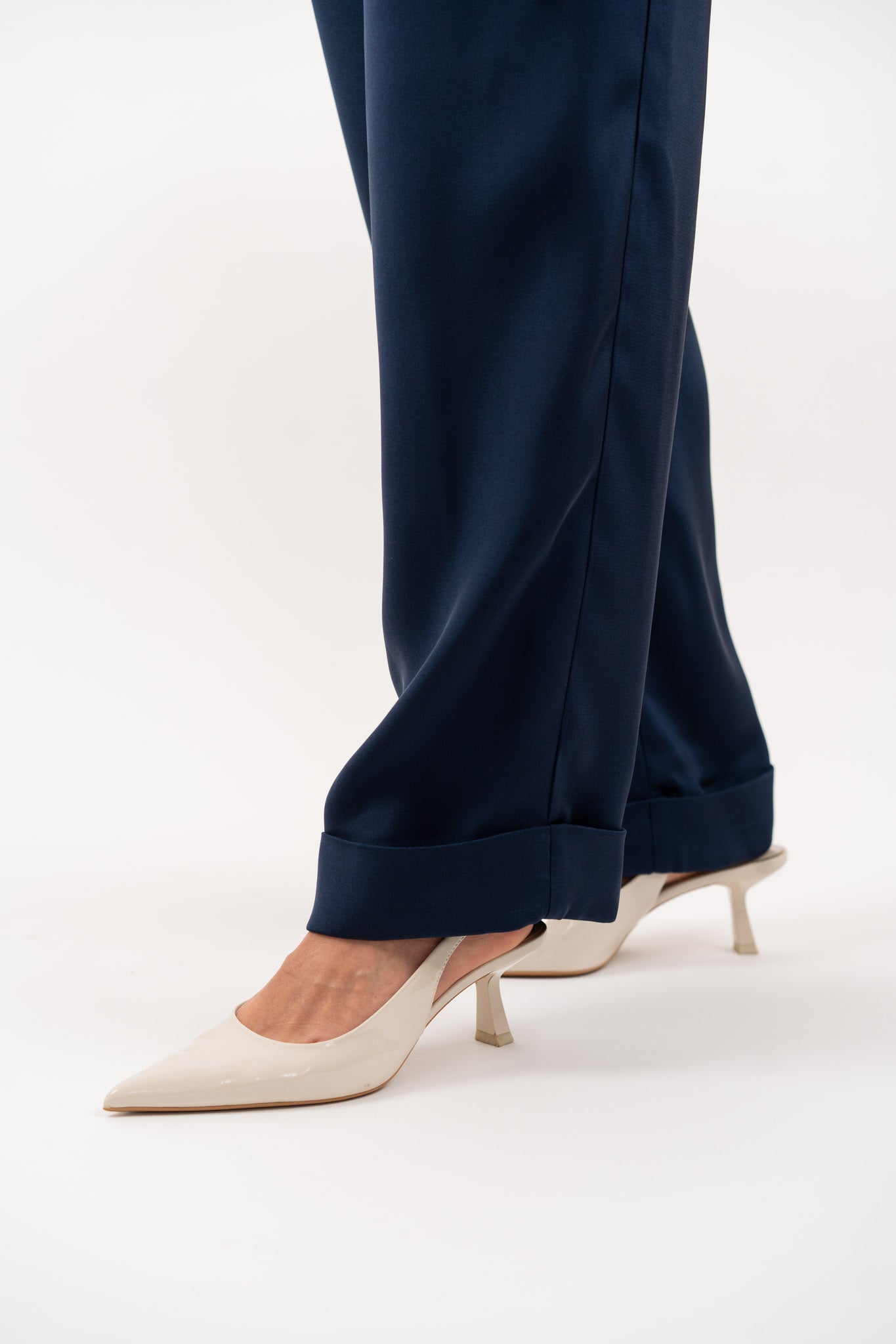 Close-up of navy blue tailored silk trousers, showcasing the soft sheen of silk blend fabric, impeccable stitching, and refined craftsmanship.