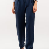 Close-up of navy blue tailored silk trousers, showcasing the soft sheen of silk blend fabric, impeccable stitching, and refined craftsmanship.