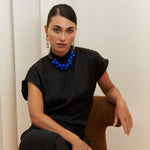 Midnight Muse Top, crafted from 100% certified Como silk, features a sleek silhouette with a refined V-neckline at the back. Its elegant drape and timeless design offer a sophisticated touch, effortlessly transitioning from daytime refinement to evening allure.