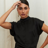 Midnight Muse Top, crafted from 100% certified Como silk, features a sleek silhouette with a refined V-neckline at the back. Its elegant drape and timeless design offer a sophisticated touch, effortlessly transitioning from daytime refinement to evening allure.