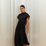 Midnight Muse Top, crafted from 100% certified Como silk, features a sleek silhouette with a refined V-neckline at the back. Its elegant drape and timeless design offer a sophisticated touch, effortlessly transitioning from daytime refinement to evening allure.
