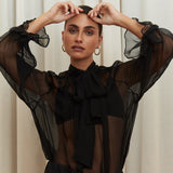 Noir Veil Blouse in 100% certified Como silk voile offers sheer elegance with voluminous sleeves and a delicate necktie—ideal for refined, modern styling.
