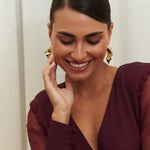 Amethyst Grace Dress in rich burgundy features a golden zamak accessory, sheer sleeves, and silk-covered buttons for opulent sophistication at formal events.