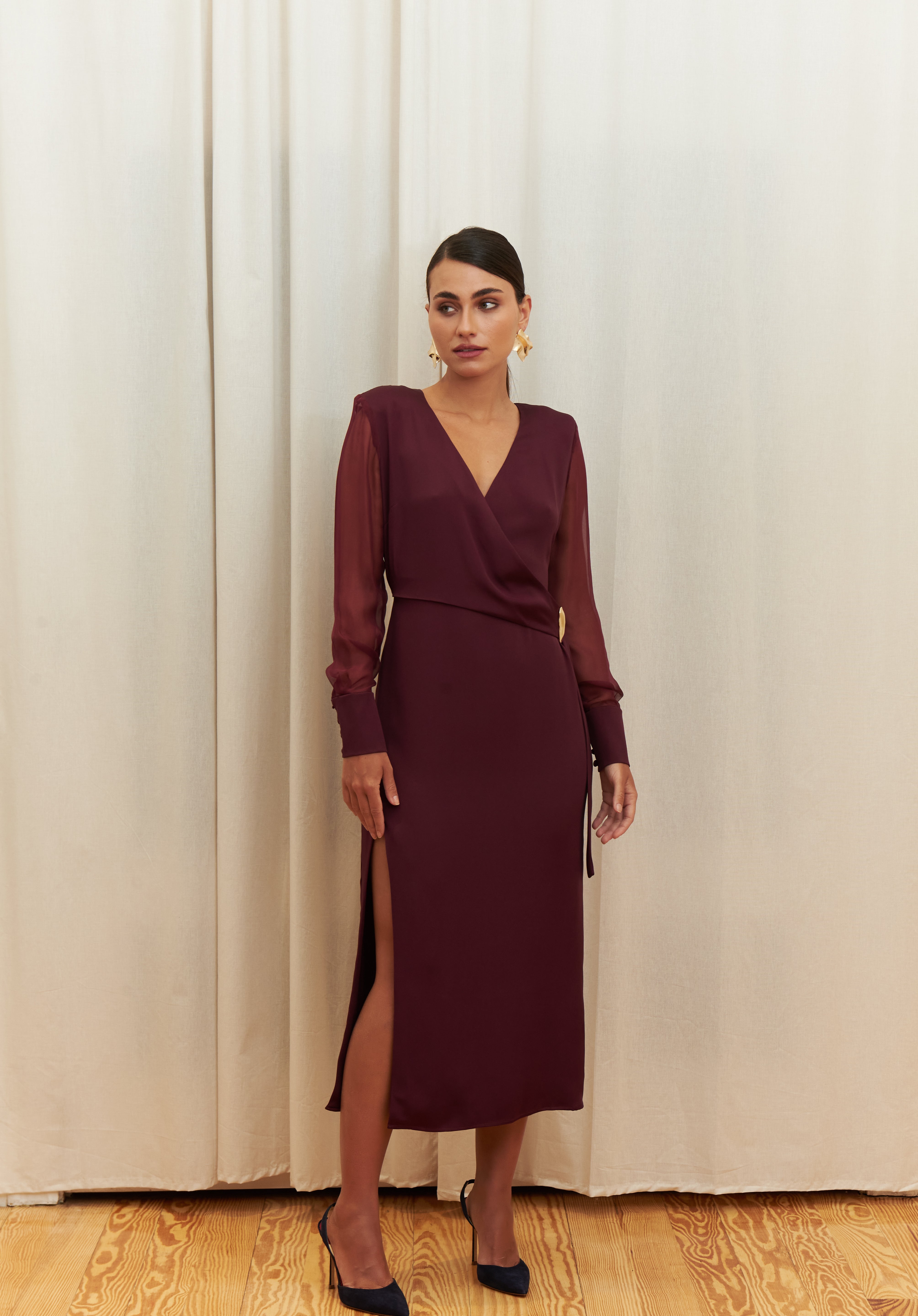 Amethyst Grace Dress in rich burgundy features a golden zamak accessory, sheer sleeves, and silk-covered buttons for opulent sophistication at formal events.