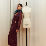 Amethyst Grace Dress in rich burgundy features a golden zamak accessory, sheer sleeves, and silk-covered buttons for opulent sophistication at formal events.