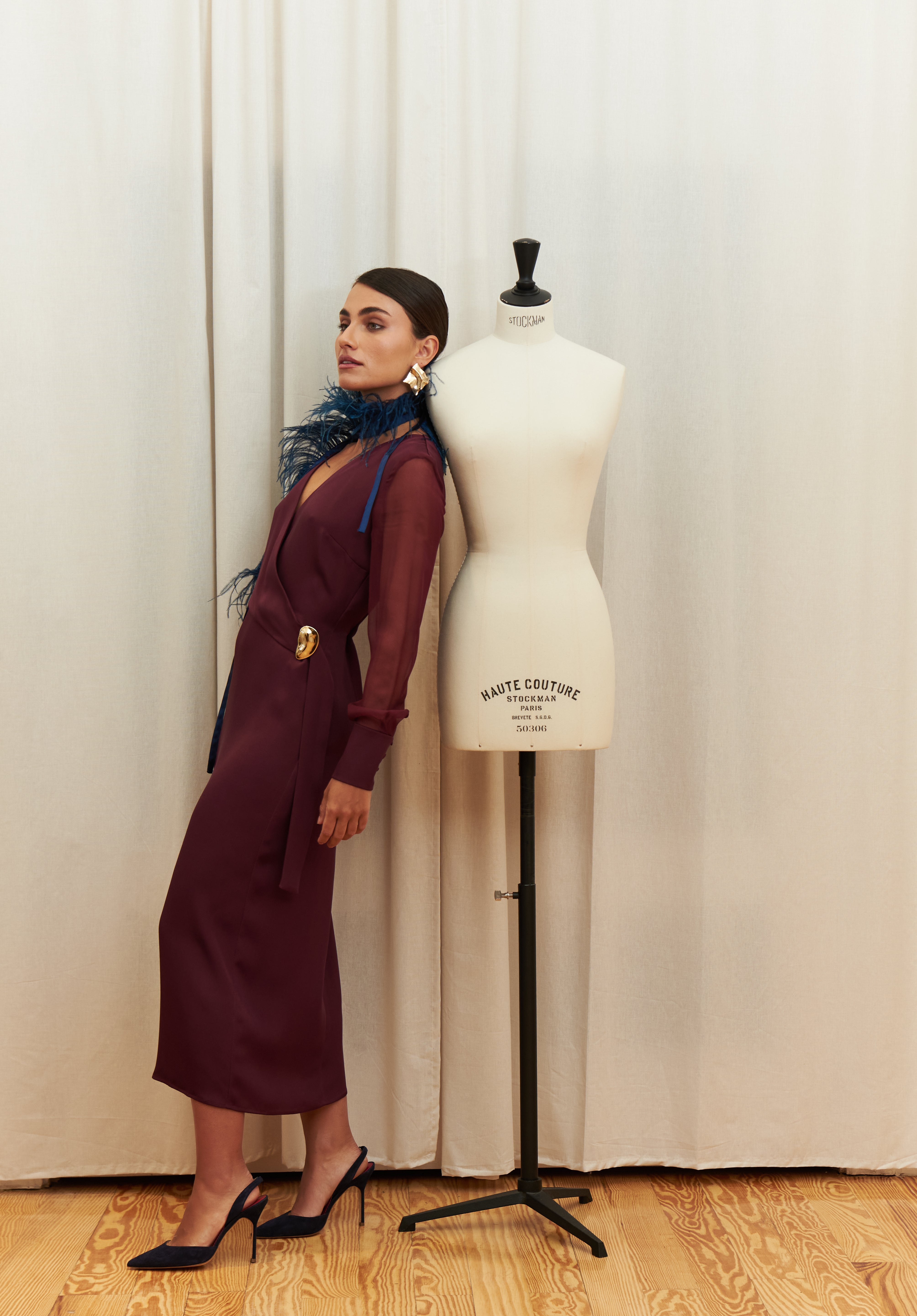 Amethyst Grace Dress in rich burgundy features a golden zamak accessory, sheer sleeves, and silk-covered buttons for opulent sophistication at formal events.