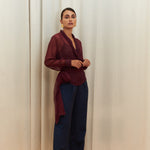 Berry Dusk Blouse in rich burgundy hue features a wrap design with silk-covered buttons and an adjustable waist tie - perfect for sophisticated day-to-evening wear.