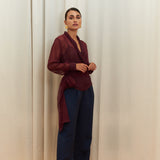Berry Dusk Blouse in rich burgundy hue features a wrap design with silk-covered buttons and an adjustable waist tie - perfect for sophisticated day-to-evening wear.