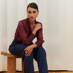 Berry Dusk Blouse in rich burgundy hue features a wrap design with silk-covered buttons and an adjustable waist tie - perfect for sophisticated day-to-evening wear.