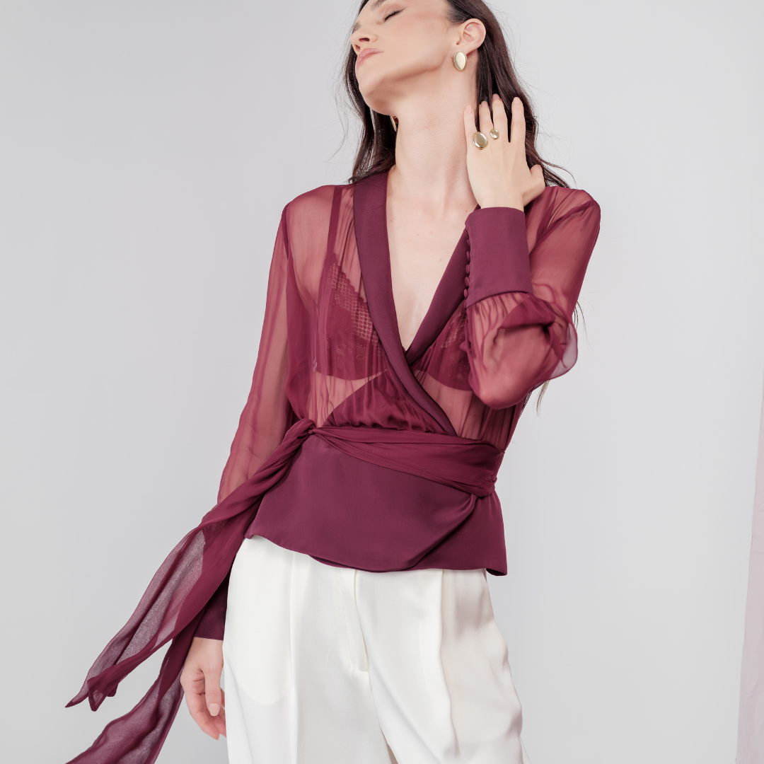 Berry Dusk Blouse in rich burgundy hue features a wrap design with silk-covered buttons and an adjustable waist tie - perfect for sophisticated day-to-evening wear.