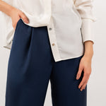 Close-up of navy blue tailored silk trousers, showcasing the soft sheen of silk blend fabric, impeccable stitching, and refined craftsmanship.