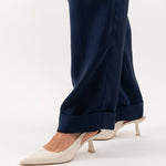 Close-up of navy blue tailored silk trousers, showcasing the soft sheen of silk blend fabric, impeccable stitching, and refined craftsmanship.