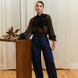 Close-up of navy blue tailored silk trousers, showcasing the soft sheen of silk blend fabric, impeccable stitching, and refined craftsmanship.