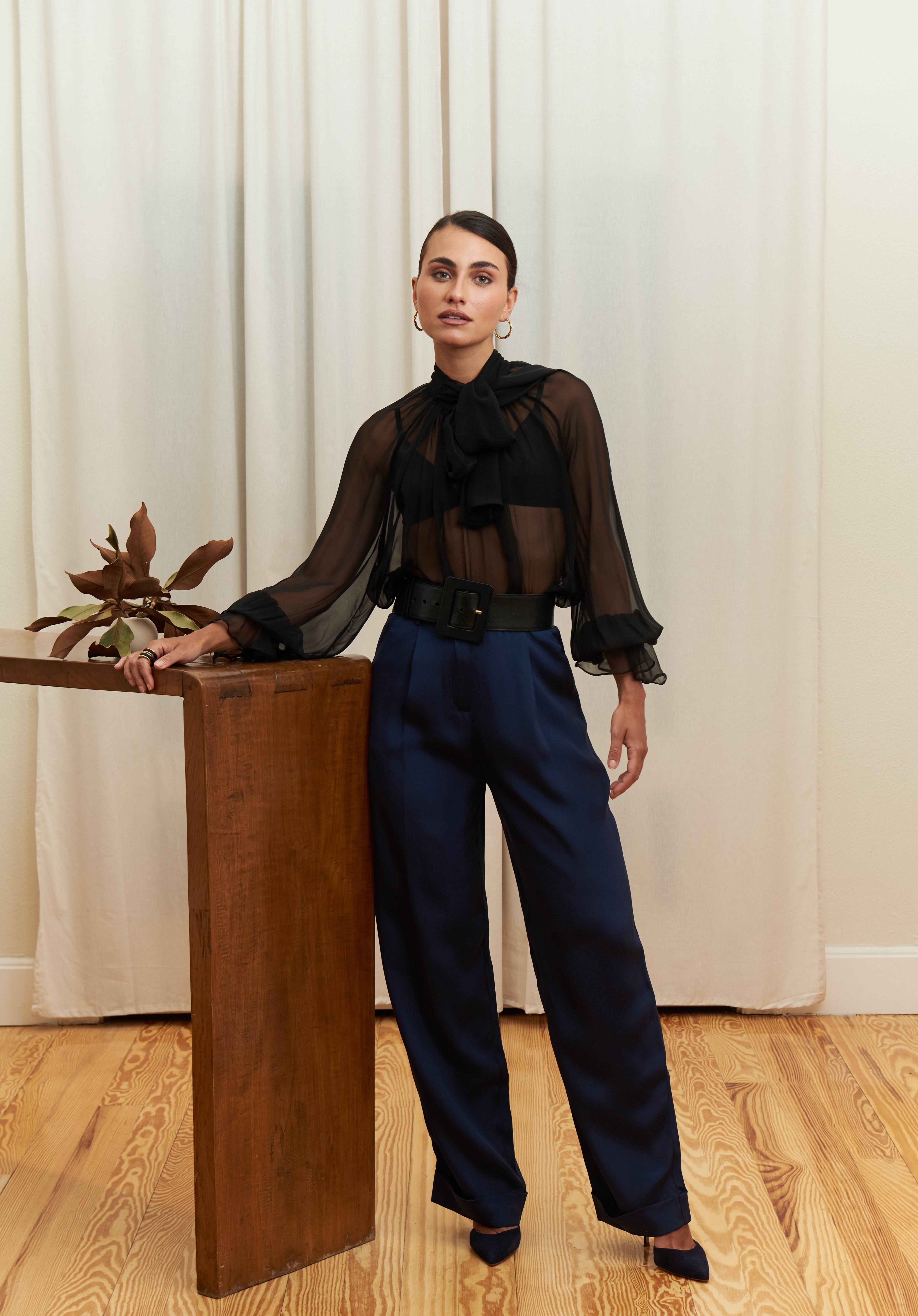 Close-up of navy blue tailored silk trousers, showcasing the soft sheen of silk blend fabric, impeccable stitching, and refined craftsmanship.