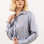 Striped silk shirt – side view featuring vertical navy and white stripes, a relaxed fit, and smooth silk drape.