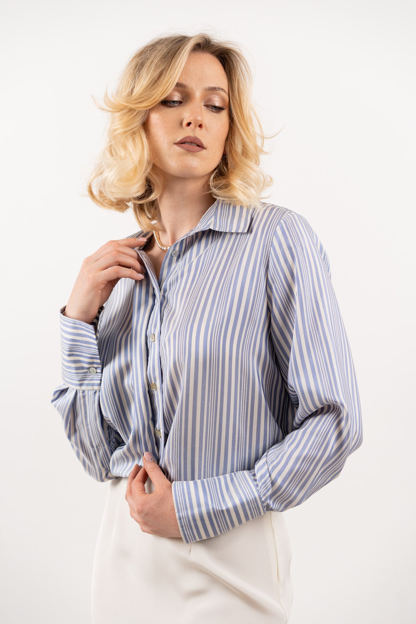 Striped silk shirt – side view featuring vertical navy and white stripes, a relaxed fit, and smooth silk drape.